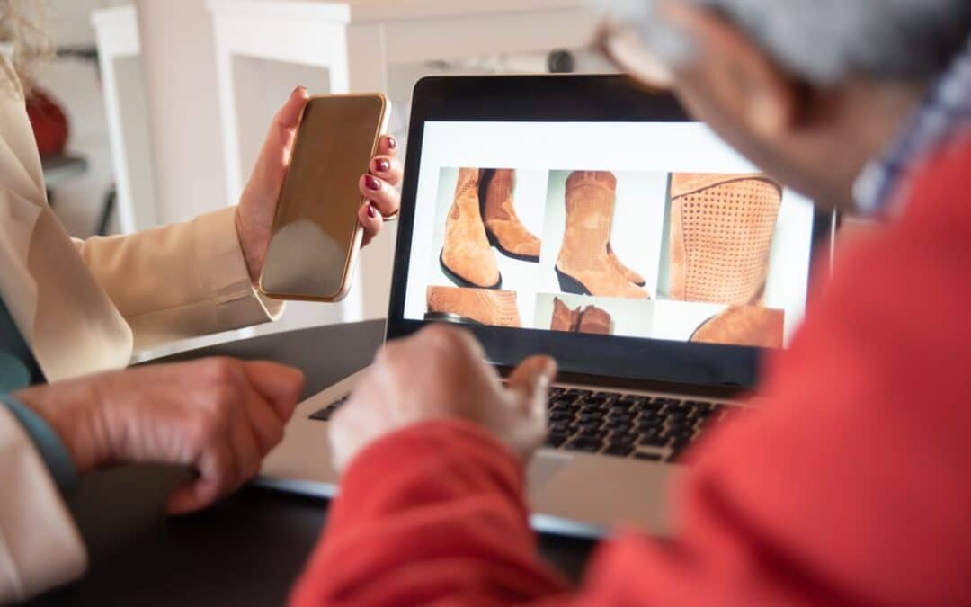 Twee mensen bekijken samen een webshop op een laptop en telefoon