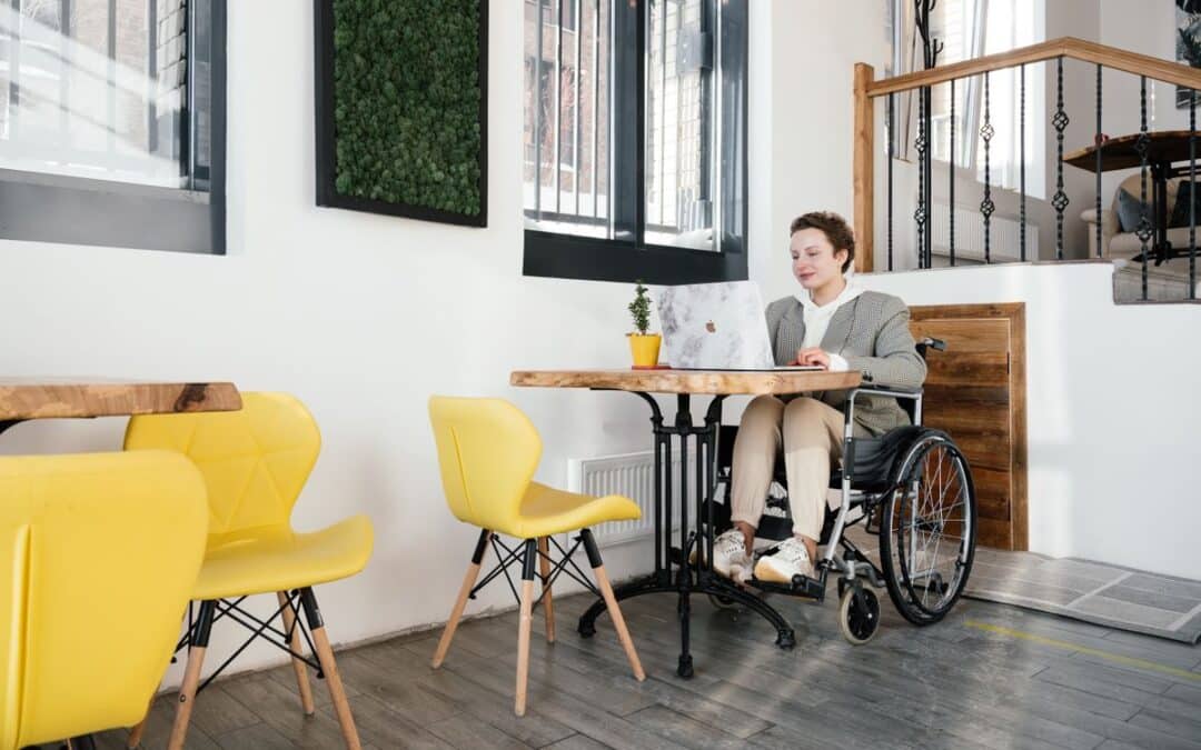 Vrouw in een rolstoel bestelt iets online via haar laptop