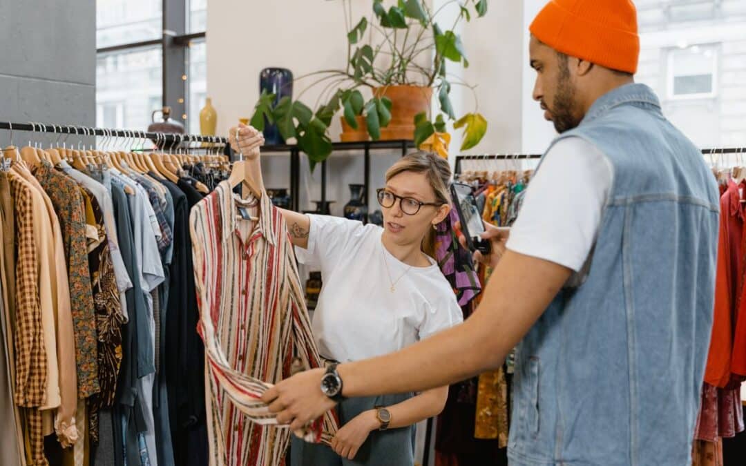 Verkoopster helpt een klant bij het kiezen van kleding in een winkel