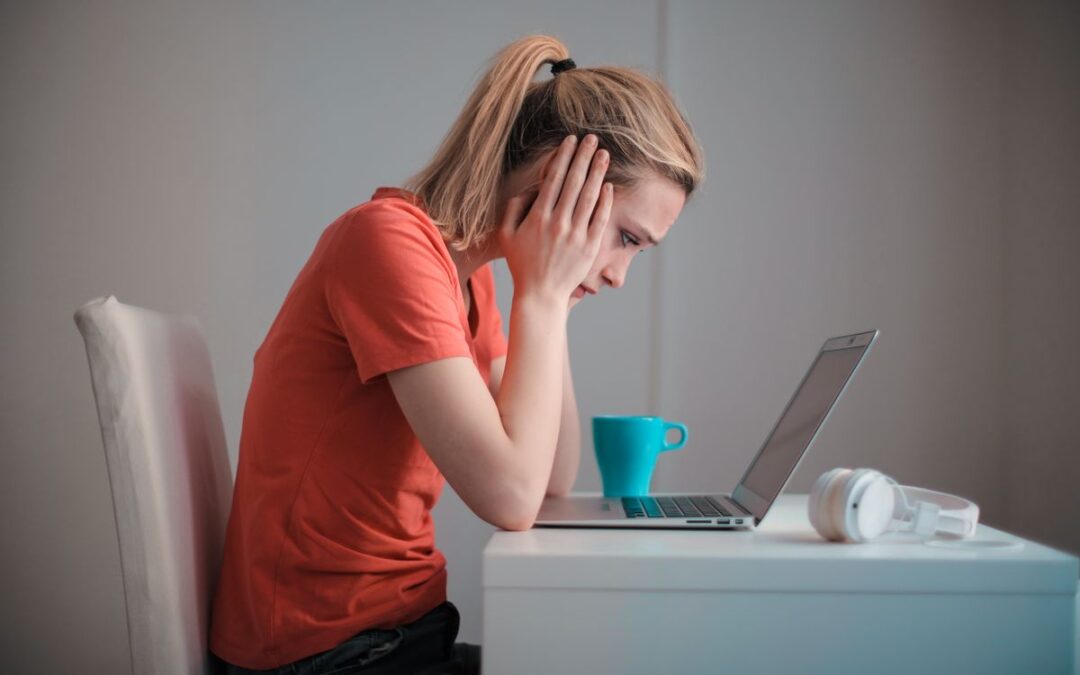 Jonge vrouw kijkt bezorgd naar haar laptop na een waarschuwing over een datalek bij een webshop