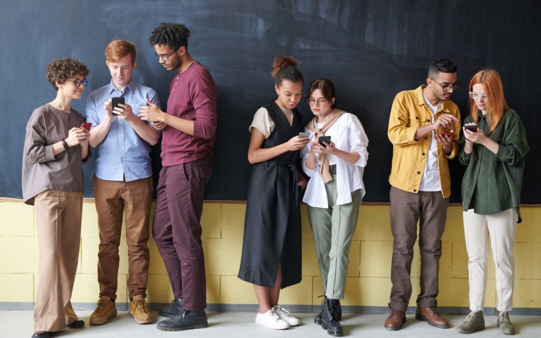 Groep diverse mensen kijkt op hun smartphone, symbool voor phishing en online betalen