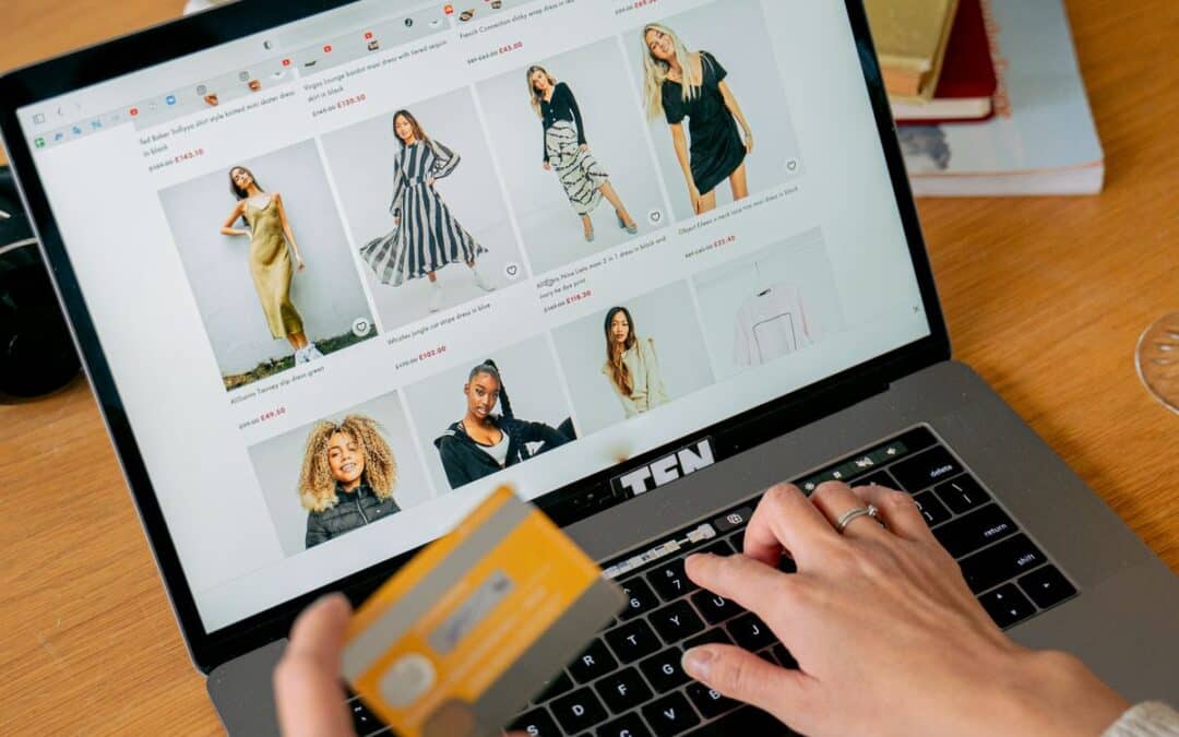 Vrouw betaalt met creditcard tijdens online winkelen op laptop bij een modewebshop