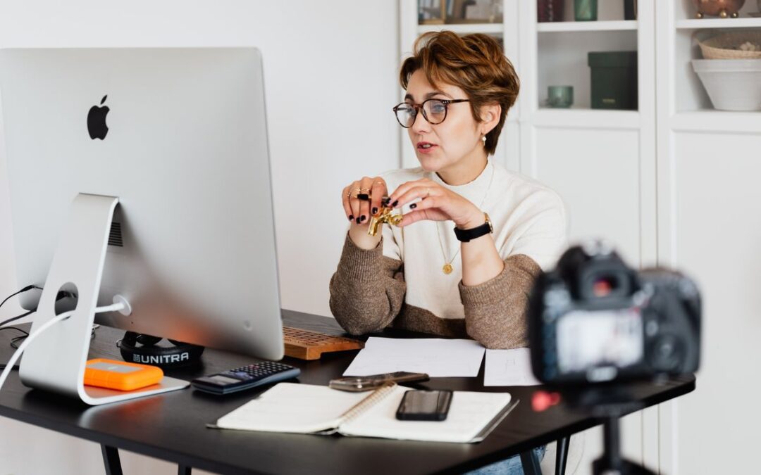 Ondernemer achter een computer in een thuiswerkplek, bezig met het online uitleggen van een bestelling