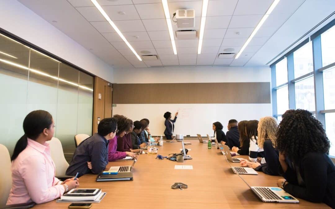 Team van een webwinkel in overleg in een vergaderruimte, een collega presenteert op het whiteboard