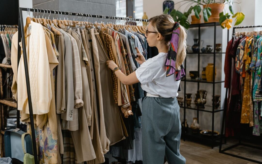 Vrouw bekijkt kleding aan een rek in een fysieke winkel